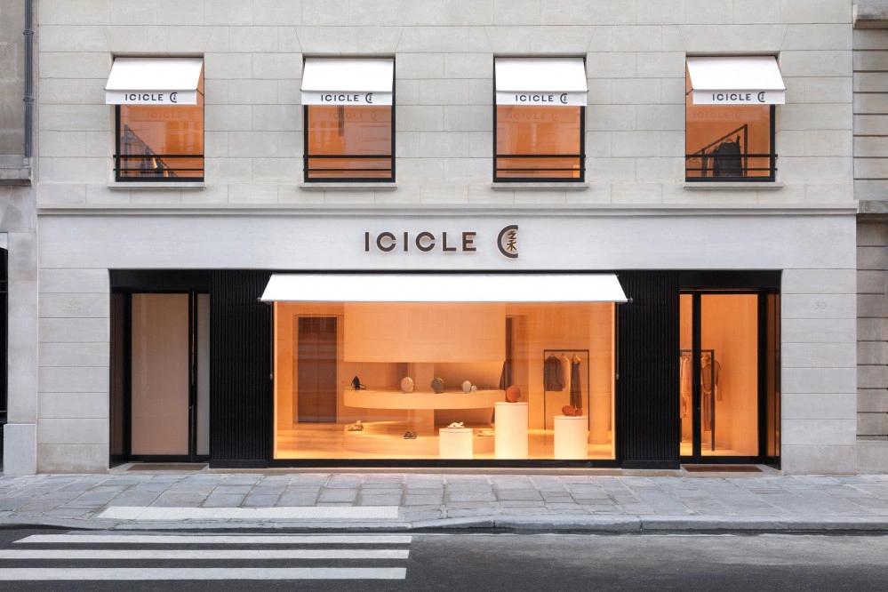 Storefront displaying clothing and accessories, viewed from the street. Awning and windows show text: "ICICLE".
