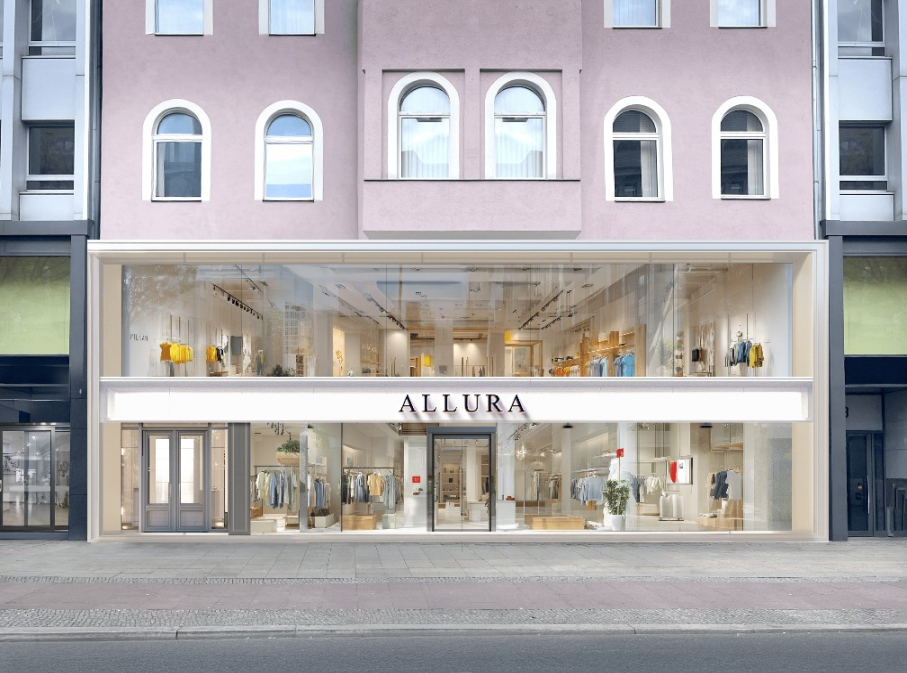 Storefront displays clothing inside a glass-walled building. Text: "ALLURA".